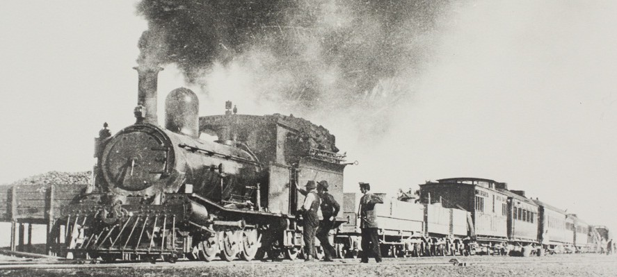 North bound Ghan train at Wiiliam Creek on old Transcontinental Railway route. Shows steam locomotive. (Northern Territory Government Photographer Collection.)